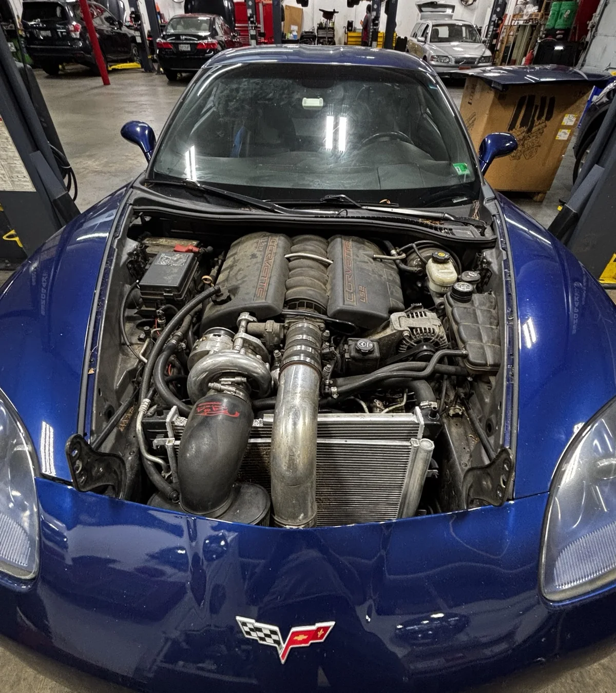 Blue Corvette with a modified engine bay open for service